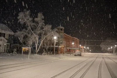 A serene winter street in Wabasha, MN, covered in snow at night.