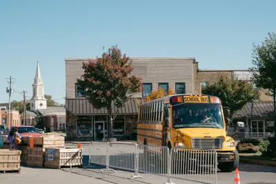 Charming small town street with a school bus and autumn trees.