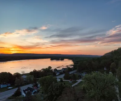 Beautiful aerial view of Reads Landing, MN, at sunset over the Mississippi River with scenic roads and trees.